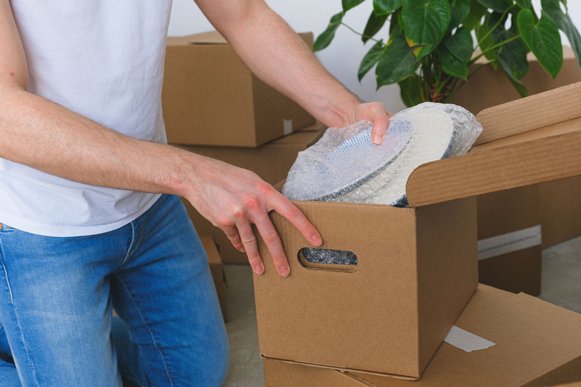 Cartons de déménagement emballés avec du papier bulle et du scotch sur un parquet