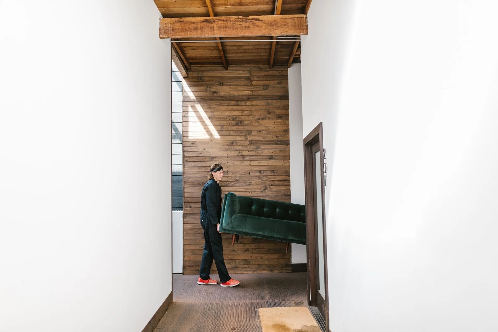 Deux déménageurs professionnels transportant un piano droit dans un couloir